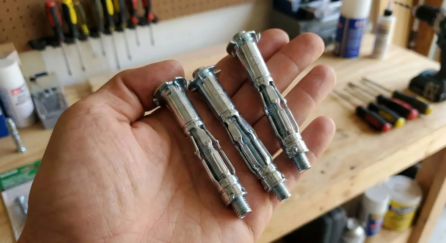 Gros plan sur des chevilles métalliques type Molly pour fixer des charges lourdes dans le placo