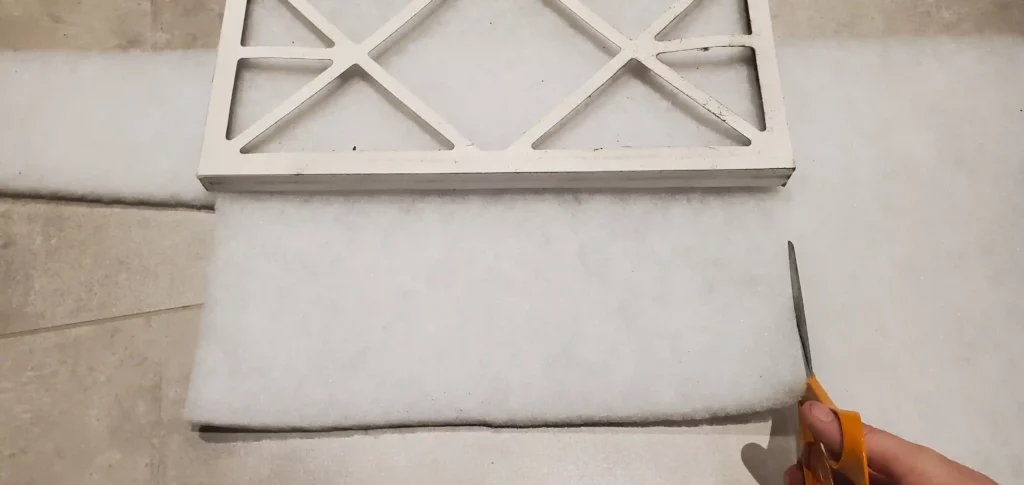 Tutoriel montrant la découpe aux ciseaux d'un média filtrant G4 ou F5 en utilisant l'ancien cadre du filtre comme gabarit.