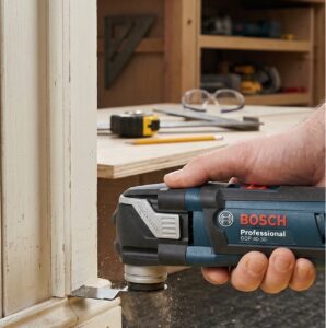 Utilisation en situation réelle de l'outil multifonction Bosch Professional GOP 40-30 pour la découpe précise d'une pièce en bois.