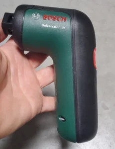 Utilisation de la brosse de nettoyage electrique Bosch UniversalBrush pour nettoyer des outils dans un atelier de bricolage