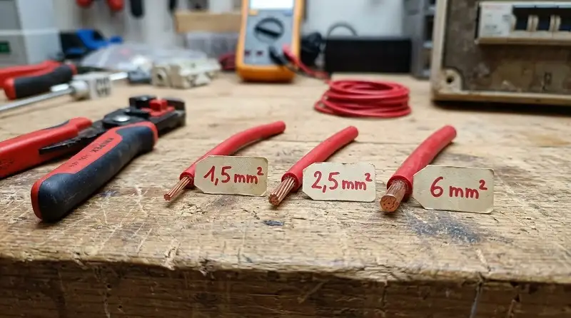 Comparatif de diamètre d'âme en cuivre entre un fil 1,5 mm², 2,5 mm² et 6 mm² sur établi d'atelier